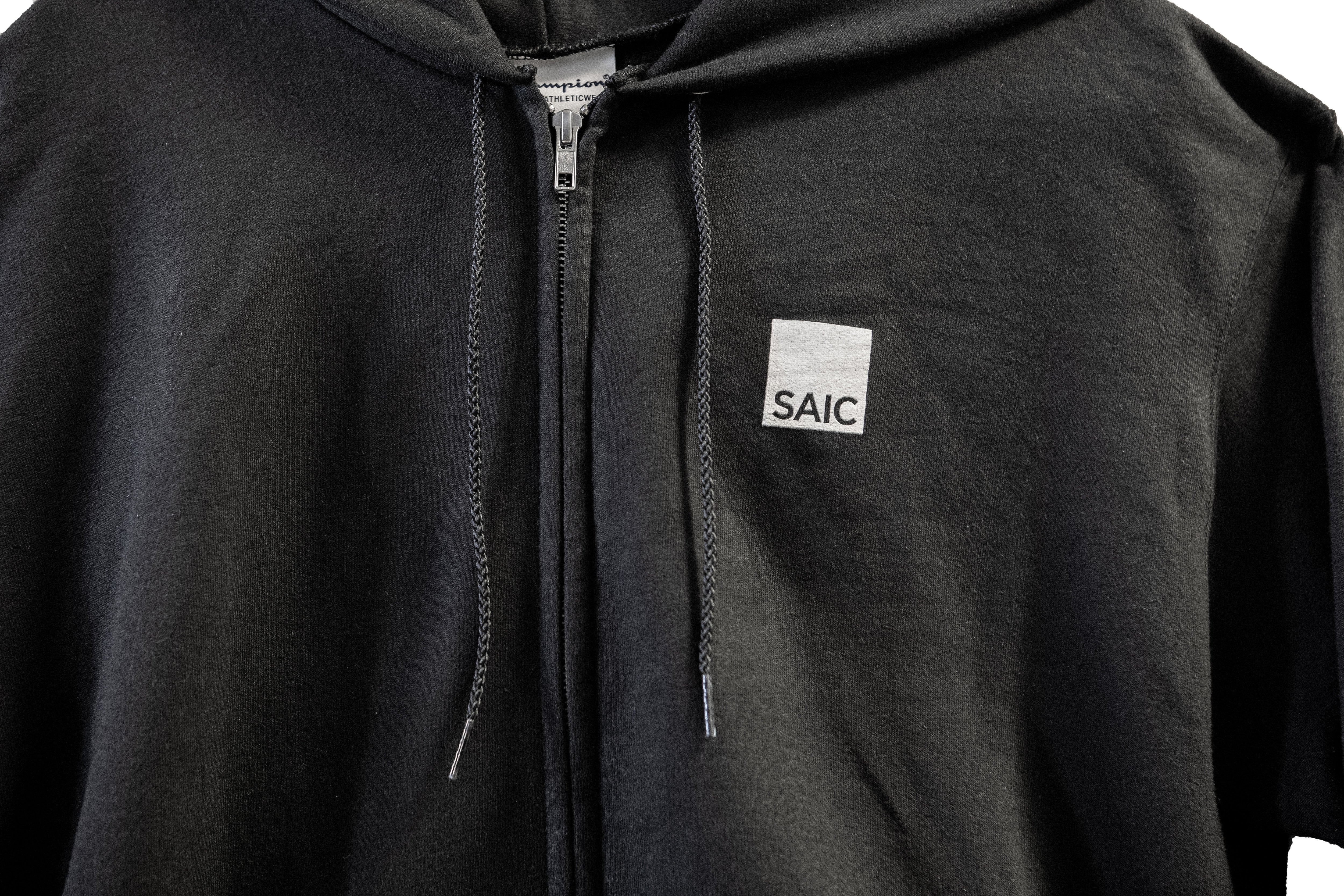 Black hoodie with a small white logo on the chest